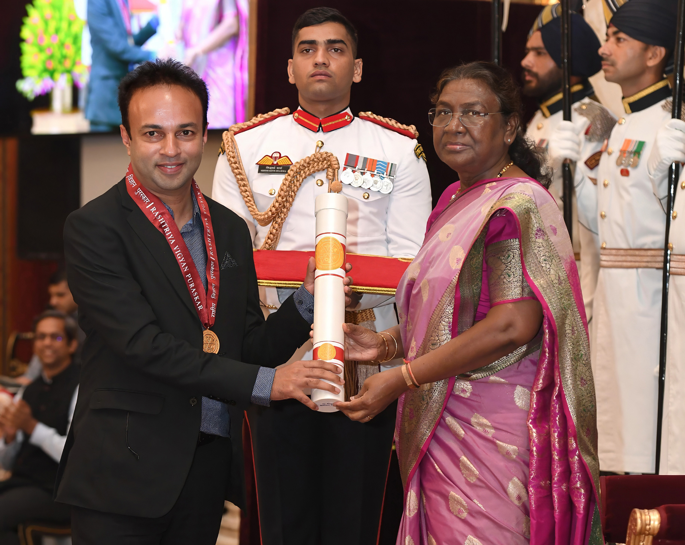 The President of India, Droupadi Murmu, presents the Rashtriya Vigyan Puraskar in Earth Science to Roxy Mathew Koll at the Rashtrapati Bhavan, Delhi